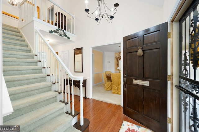 entrance foyer with an inviting chandelier, hardwood / wood-style flooring, and a high ceiling