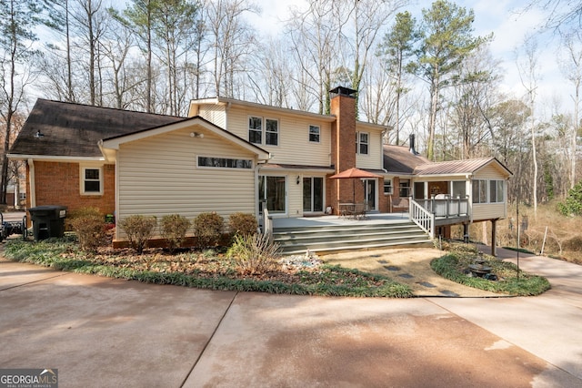 back of property featuring a wooden deck and a sunroom