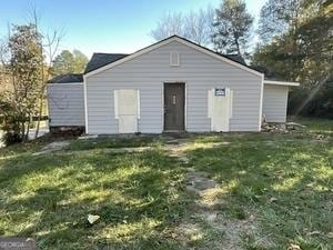 rear view of property featuring a lawn