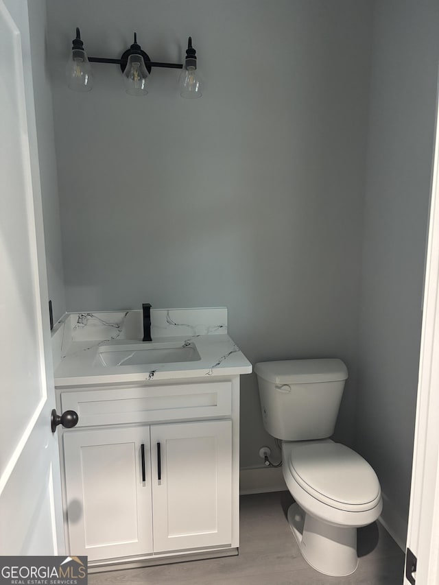 bathroom featuring vanity, hardwood / wood-style floors, and toilet