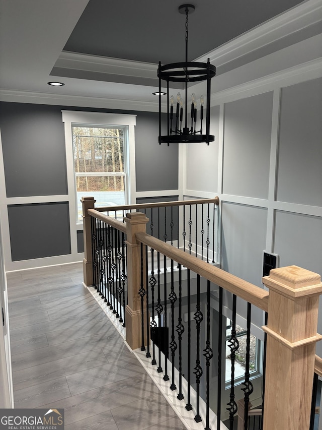 corridor featuring a tray ceiling, crown molding, and a healthy amount of sunlight