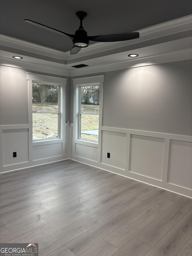 spare room with ceiling fan, crown molding, and light wood-type flooring