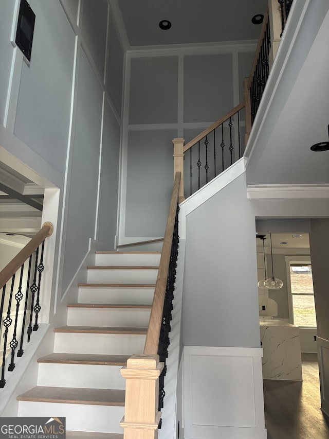 stairway featuring hardwood / wood-style floors and a towering ceiling