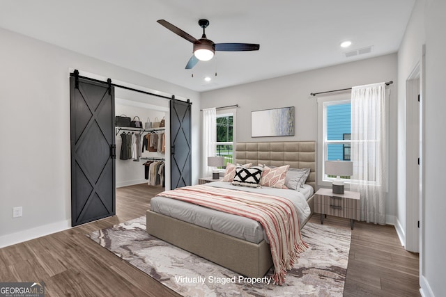133 Old Alabama Rd SE, Emerson, GA 30137 - bedroom with a barn door, wood finished floors, a walk in closet, ceiling fan, and recessed lighting