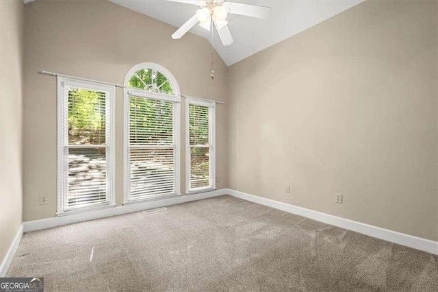 spare room featuring ceiling fan, plenty of natural light, high vaulted ceiling, and light carpet