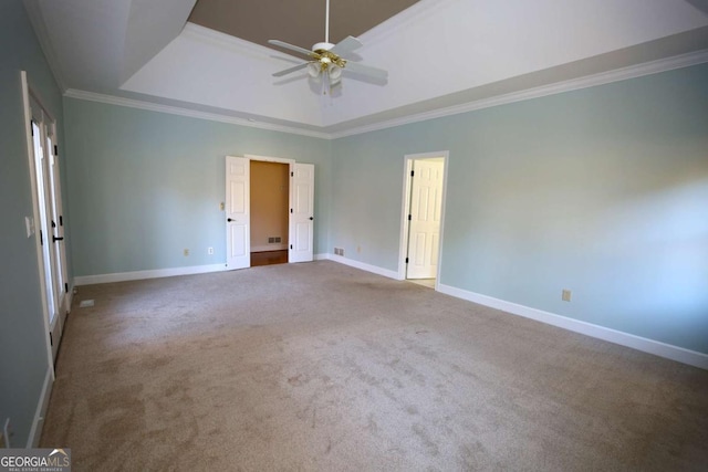 carpeted spare room with crown molding, ceiling fan, and a tray ceiling