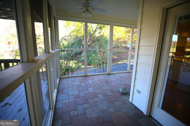 unfurnished sunroom with ceiling fan and a wealth of natural light