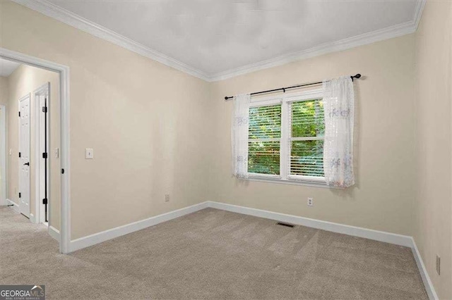 empty room with ornamental molding and light carpet