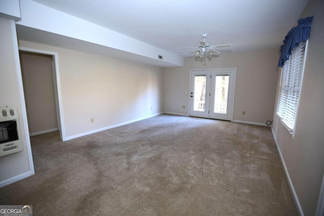 empty room with heating unit, carpet floors, and ceiling fan