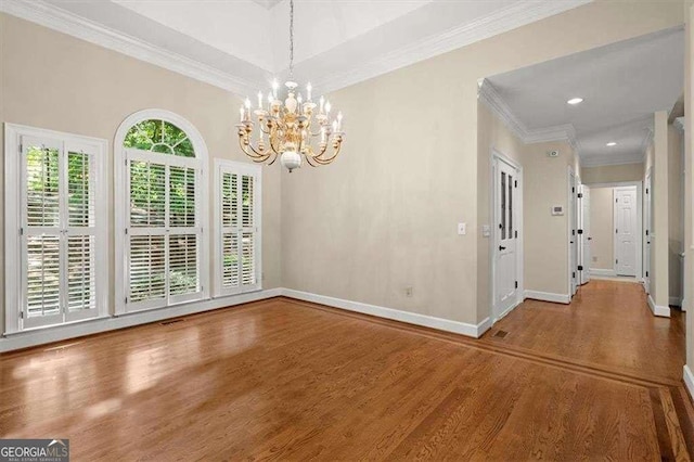 unfurnished dining area with crown molding, hardwood / wood-style flooring, and a chandelier