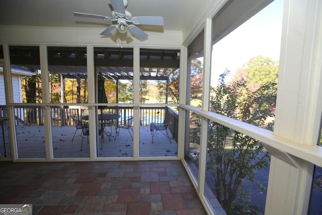 unfurnished sunroom featuring a wealth of natural light and ceiling fan