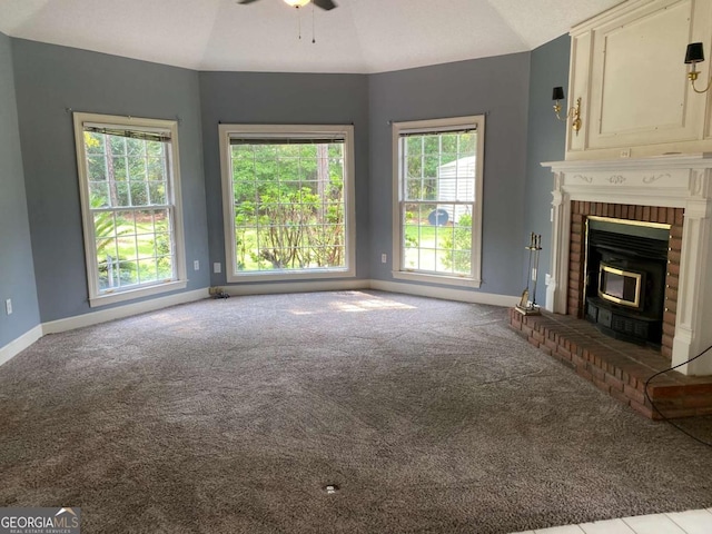 unfurnished living room with lofted ceiling, a fireplace, light colored carpet, and ceiling fan