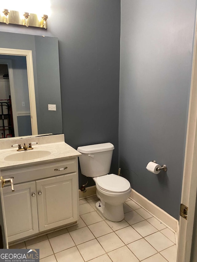 bathroom with tile patterned flooring, vanity, and toilet