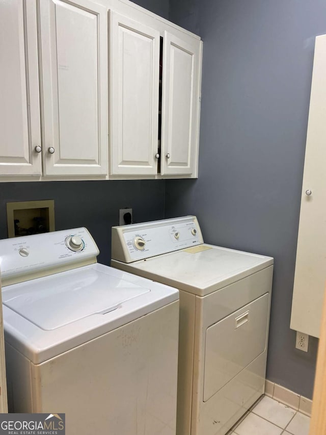 laundry area with cabinets, light tile patterned flooring, and separate washer and dryer