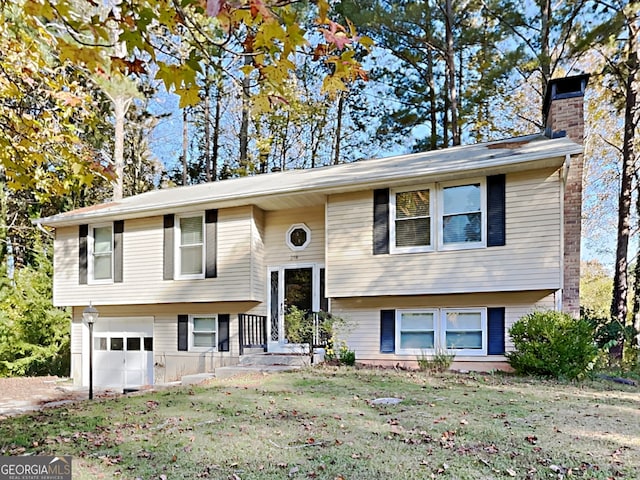 bi-level home featuring a garage and a front lawn