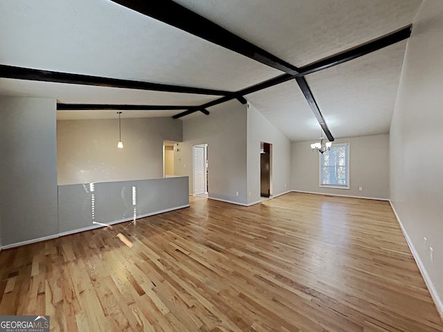 unfurnished living room featuring vaulted ceiling with beams, a notable chandelier, and light hardwood / wood-style floors