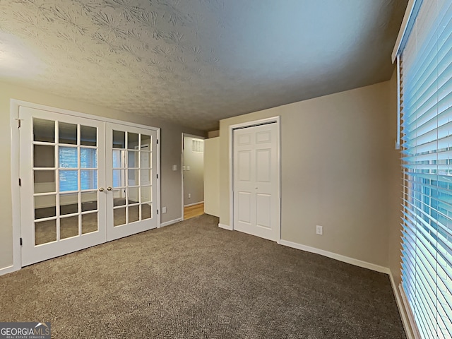 unfurnished bedroom featuring french doors, a closet, carpet flooring, and a textured ceiling