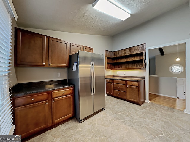 kitchen featuring lofted ceiling, stainless steel fridge, and a textured ceiling