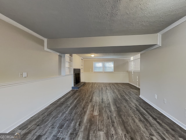 unfurnished living room with dark hardwood / wood-style floors, a brick fireplace, and a textured ceiling