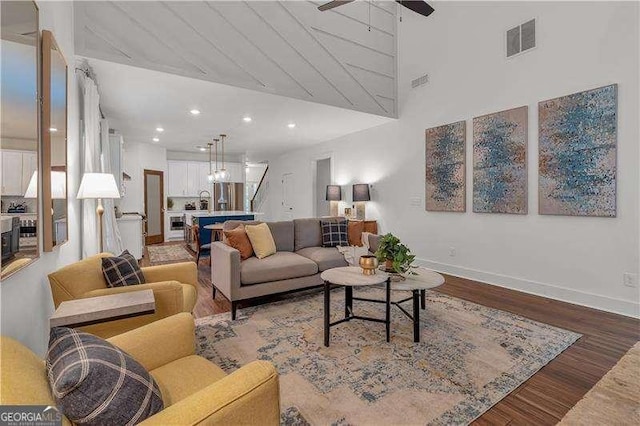 living area featuring baseboards, visible vents, recessed lighting, a ceiling fan, and wood finished floors
