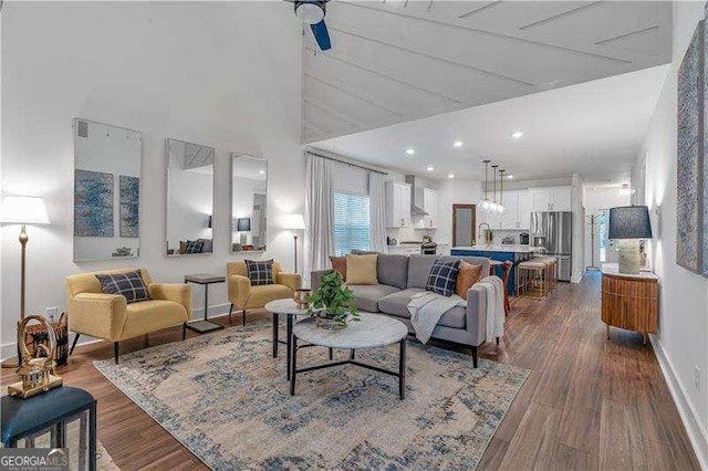 living area with baseboards and dark wood finished floors