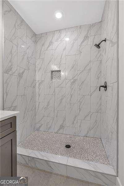 full bath featuring a tile shower, vanity, and recessed lighting