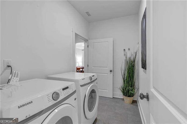 laundry area with baseboards, visible vents, washer and clothes dryer, and laundry area