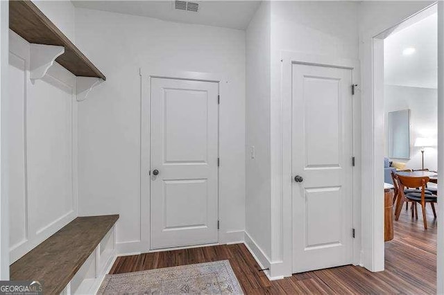 interior space with baseboards, dark wood-style flooring, and visible vents