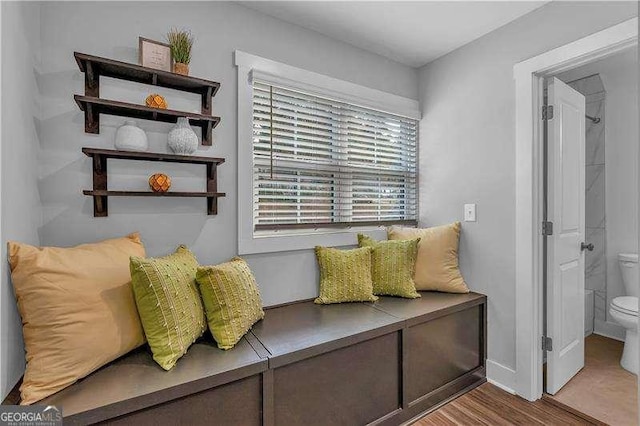 living area featuring baseboards and wood finished floors
