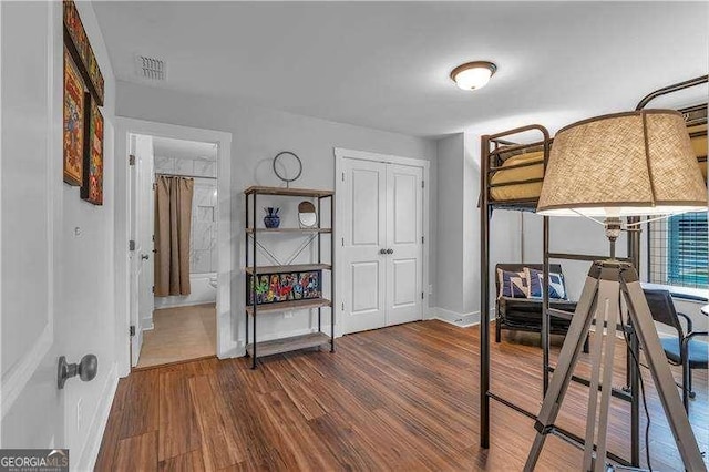 bedroom featuring baseboards, wood finished floors, and visible vents
