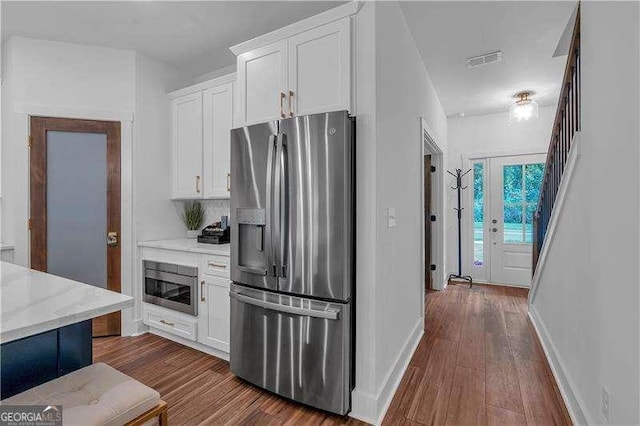 kitchen with white cabinets, visible vents, dark wood-style floors, and stainless steel appliances