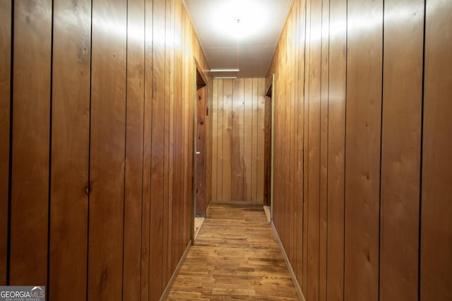 hall with wooden walls and light wood-type flooring