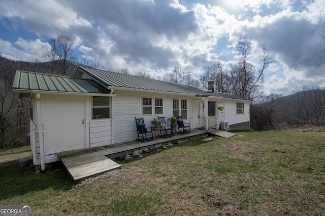 back of house featuring a wooden deck and a yard