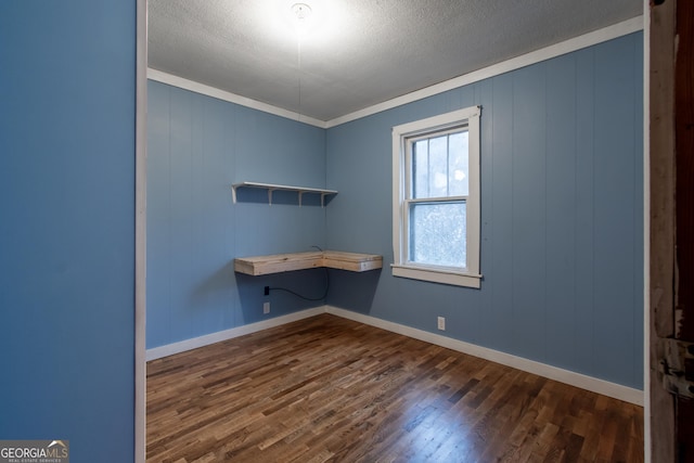 unfurnished office featuring ornamental molding, dark hardwood / wood-style flooring, and a textured ceiling