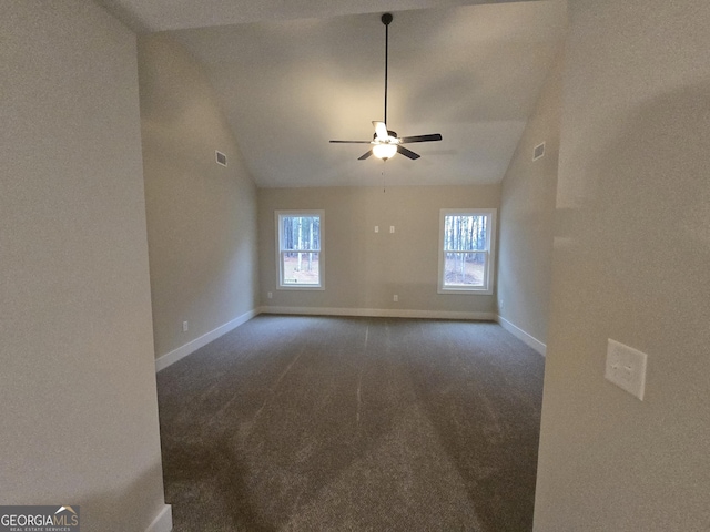 unfurnished room with ceiling fan, lofted ceiling, and dark carpet