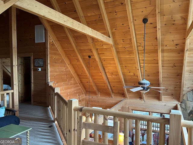 interior space with vaulted ceiling with beams, dark carpet, wooden walls, and wooden ceiling