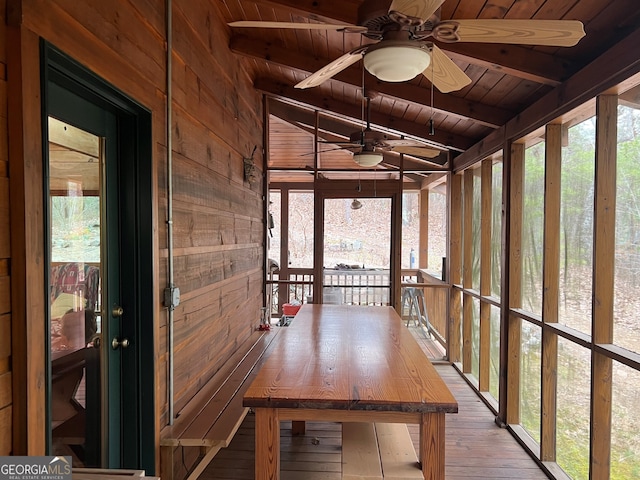 unfurnished sunroom with lofted ceiling with beams, wooden ceiling, and ceiling fan