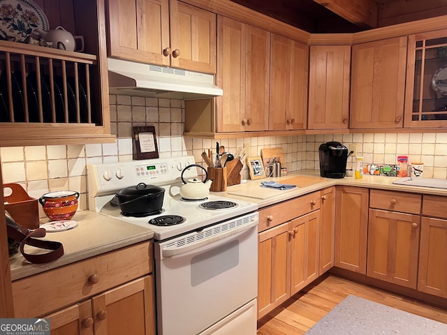 kitchen with tasteful backsplash, light hardwood / wood-style floors, and white range with electric stovetop