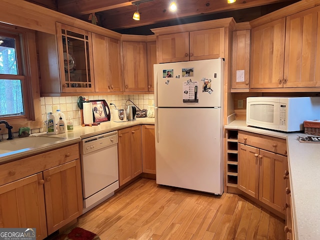 kitchen featuring sink, decorative backsplash, white appliances, and light hardwood / wood-style flooring