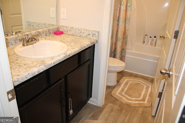 full bathroom with vanity, hardwood / wood-style floors, shower / bath combination with curtain, and toilet