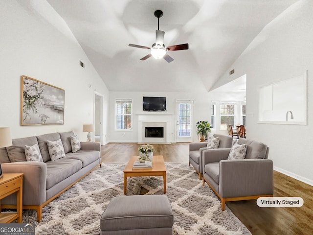 living room with wood-type flooring, ceiling fan, and high vaulted ceiling