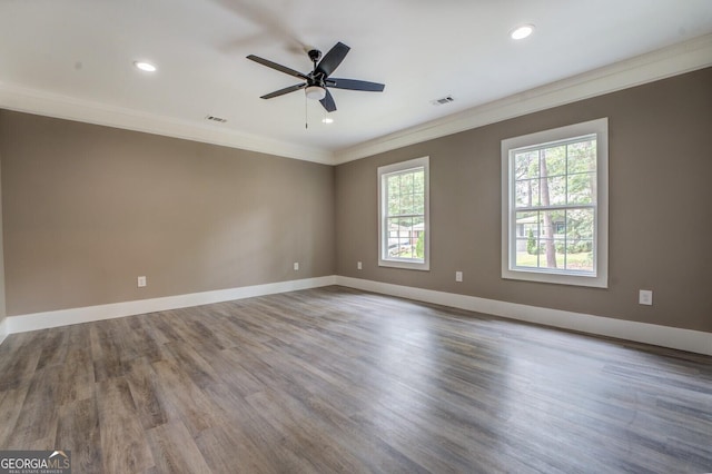 empty room featuring hardwood / wood-style flooring, ornamental molding, and ceiling fan