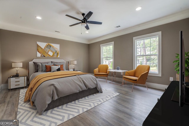 bedroom featuring ceiling fan, ornamental molding, and light hardwood / wood-style flooring