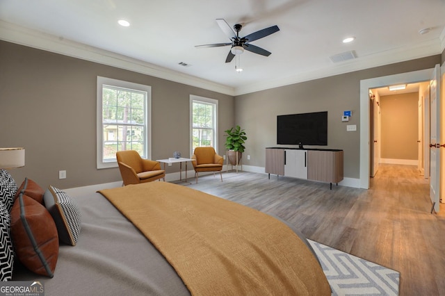 bedroom featuring ornamental molding, ceiling fan, and light wood-type flooring