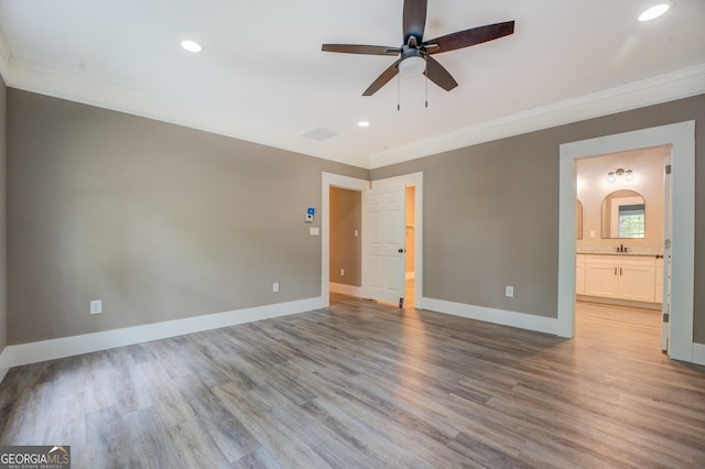 spare room featuring crown molding and light hardwood / wood-style flooring