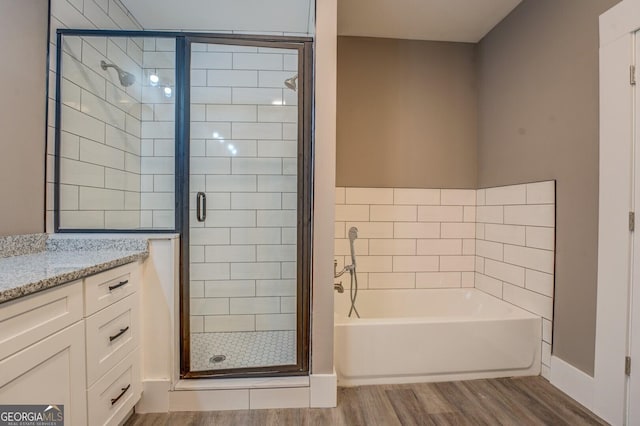 bathroom featuring vanity, hardwood / wood-style floors, and separate shower and tub