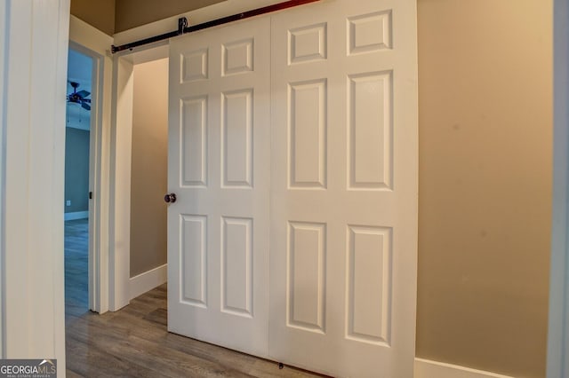 details featuring a barn door and hardwood / wood-style floors