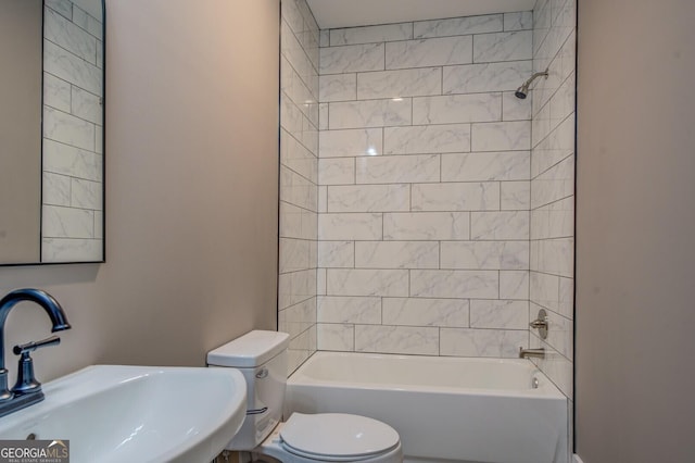 full bathroom with toilet, tiled shower / bath combo, and sink