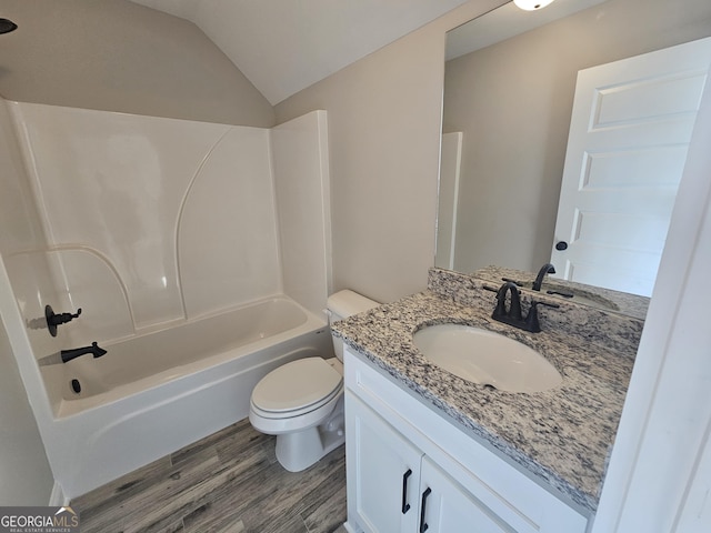 full bathroom featuring washtub / shower combination, vanity, wood-type flooring, vaulted ceiling, and toilet