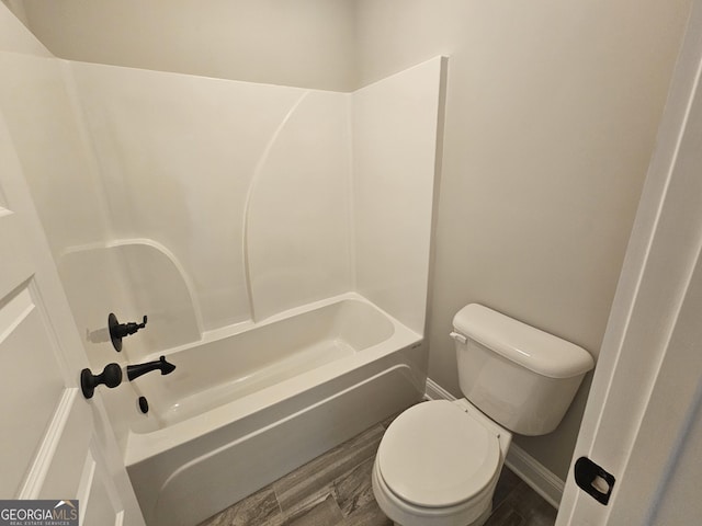 bathroom with hardwood / wood-style flooring, toilet, and bathing tub / shower combination